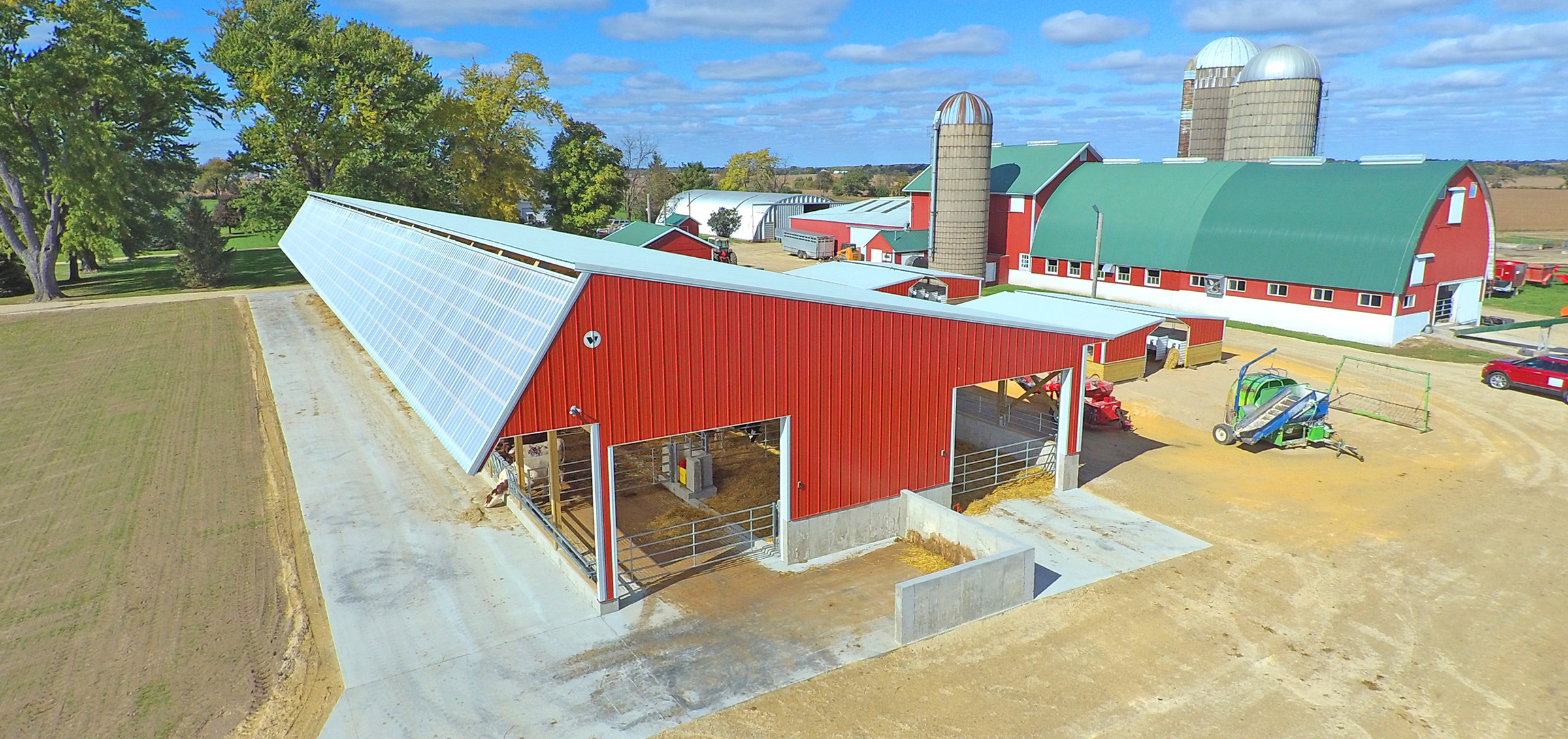 post frame agricultural building showing tractor equipment and a silo